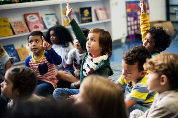 Toddler raising hand in classroom